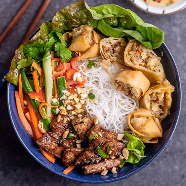 Bún — vermicelli bowl with grilled pork and egg rolls